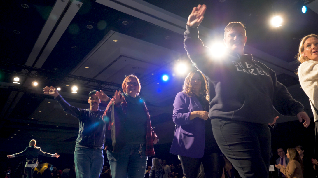 A group of people waving walking a runway